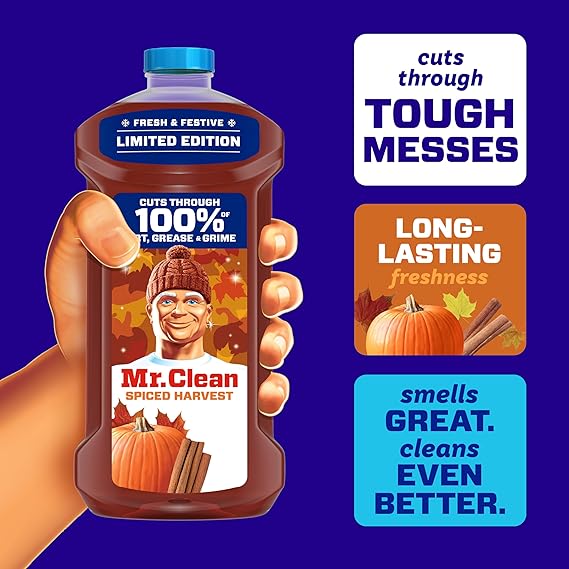 Mr. Clean Spiced Harvest cleaner bottle held by a hand with product features on a blue background
