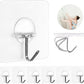 Set of metal wall hooks with adhesive backing on a white background